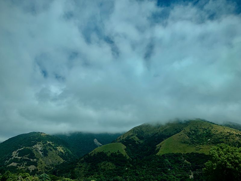 Heavy clouds and green foothills.