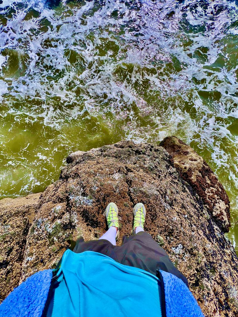 Looking at my shoes overlooking a rocky coast.